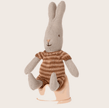 Maileg Kaninchen in gestricktem Strampler sitzt auf rosa farbenem Miniatur Töpfchen aus Holz